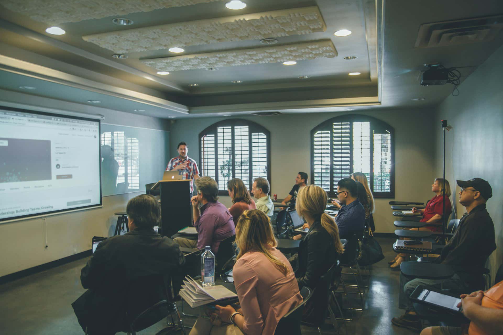 Speaker presenting to a seated group during an in-person workshop.